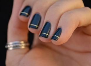 Модный дизайн ногтей, черный маникюр шеллак с золотой полоской